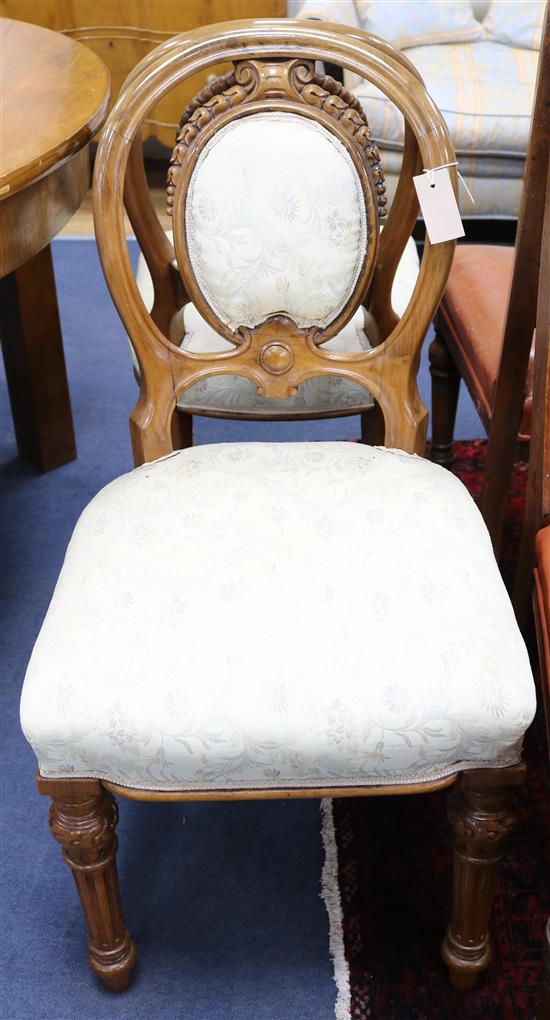 A set of six Victorian carved walnut padded balloon-backed dining chairs